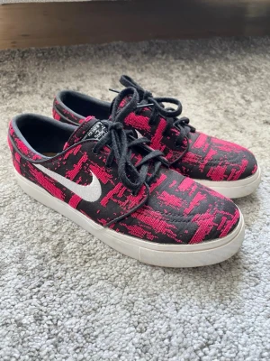 NIKE SB premium - Stefan Janoski - Unika Nike Janoski sneakers med svart och rosa digitalt mönster, vita sulor och klassisk vit Swoosh på sidan. Skorna har svarta skosnören och är låga i modellen. Använda men utan defekter