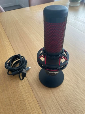 HyperX svart och röd USB-mikrofon - Säljer en HyperX mikrofon i svart och rött med USB-anslutning. Mikrofonen har ett robust metallstativ och stötdämpande upphängning. Perfekt för streaming, gaming eller podd. USB-kabel medföljer.