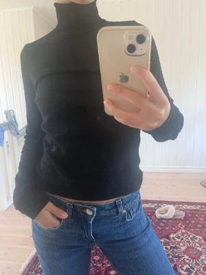 Svart polotröja i stickat material - Från Wera Åhléns. Något nopprig.