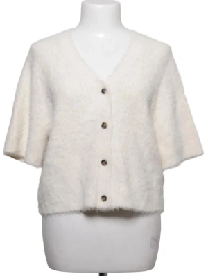 Krämvit kortärmad kofta med knappar - Mysig krämvit kofta med korta ärmar och v-ringning. Koftan har fyra bruna knappar framtill och är stickad i ett fluffigt material. Perfekt att slänga över ett linne för en chill look.