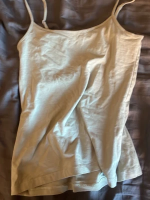 Beige linnetopp från Amisu - Snygg beige linnetopp från Amisu med tunna axelband och enkel, stilren design. Perfekt att matcha med jeans eller kjol för en avslappnad look. Tillverkad i mjuk bomull som känns skön mot huden.