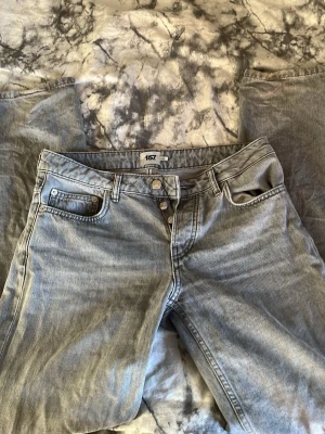 Ljusblå raka jeans från 157 - Säljer ett par lgråjeans från 157 med rak passform och klassisk femficksdesign. Jeansen har knappgylf och är tillverkade i ett slitstarkt denimtyg. Perfekta för en avslappnad och trendig look.