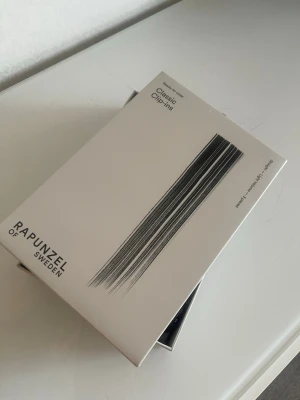 Rapunzel of Sweden Classic Clip-ins - Säljer ett paket Classic Clip-ins från Rapunzel of Sweden. Säljer classic clip-ins, light wolume straight 3 pieces i färgen black Brown 60 cm, använt en gång.