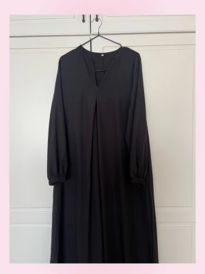 (Abaya) Svart långklänning med v-ringning - 💗En svart Abaya långklänning med v-ringad hals och långa ärmar med resår vid ärmsluten. Klänningen har en rak och lös passform, vilket ger en avslappnad och stilren look. Perfekt för dig som gillar minimalistisk stil.💗Har fler abayas om du kollar in i min profil. Pris kan diskuteras 