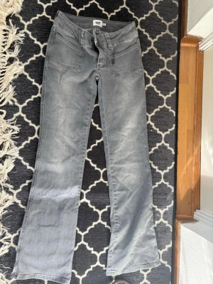 Grå bootcut jeans från 157 - Säljer ett par grå bootcut jeans från 157 med stora framfickor och klassiska bakfickor. Jeansen har en snygg tvättad look och är tillverkade i denim med lite stretch. Perfekt för dig som gillar en avslappnad och trendig stil.