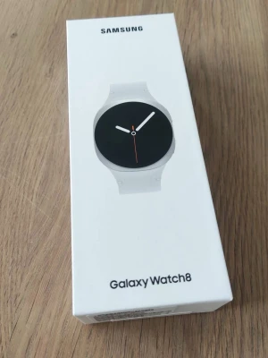 Samsung Galaxy Watch8 silver smartklocka - Samsung Galaxy Watch8 smartklocka i vit färg med rund urtavla och stilren design. Klockan har ett silikonarmband och en minimalistisk look. Perfekt för dig som vill ha koll på notiser, träning och hälsa direkt på handleden.