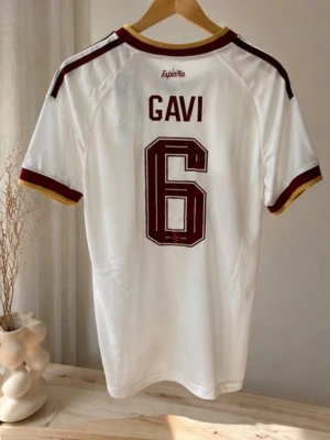 Vit Spanien fotbollströja Gavi #6 - Helt ny Spanien bortatröja med Gavi #6 på ryggen, storlek S. Taggarna sitter kvar och tröjan är aldrig använd. Beställdes innan VM då Gavi fortfarande hade nummer 6, innan han bytte till nummer 9. Snygg och unik version för både samlare och fans. Skick 10/10. Rök- och djurfritt hem. 