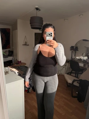 Grå ribbad halvarms topp  - Säljer en grå ribbad halv arms topp. Toppen är croppad och har en tight passform som framhäver figuren. Perfekt att styla med. 