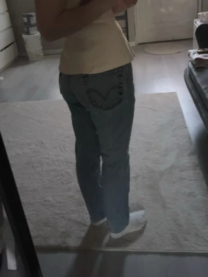 Levi's raka blå jeans W30 L32 - Säljer ett par klassiska raka blå jeans från Levi's med ikonisk bakficka och röd logga. Jeansen har normal midja och är tillverkade i slitstark denim. Perfekta för en avslappnad och trendig look.