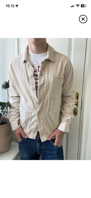 Beige overshirt i manchester - Säljer en beige overshirt i manchester med klassisk krage och tre stora fickor framtill. Jackan har raka ärmar och knäppning med ljusa knappar. Perfekt för lager-på-lager och ger en avslappnad look.