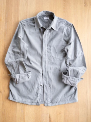 Tiger of Sweden Overshirt, size S - Stilren grå overshirt från Tiger of Sweden i bomull. Skjortan har klassisk krage, långa ärmar och knappar framtill. Perfekt lager-på-lager-plagg med enkel bröstficka och relaxed fit.