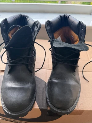 Svarta klassiska kängor i läder från Timberland - Säljer ett par svarta kängor med snörning och robust sula. Kängorna har en vadderad insida i brunt tyg och är tillverkade i slitstarkt läder. Perfekta för dig som vill ha en tidlös och stilren look till hösten eller vintern.