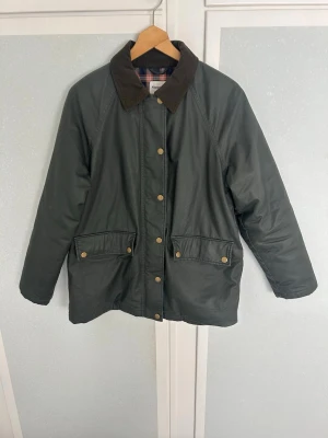 Jacka  - Vattentät jacka i storlek s  Liknar en barbour jacka  Nypris 1300 kr  Stängs med dragkedja och knappar, rymliga fickor och rutigt material på insidan  Köpt förra året och använd väldigt lite 