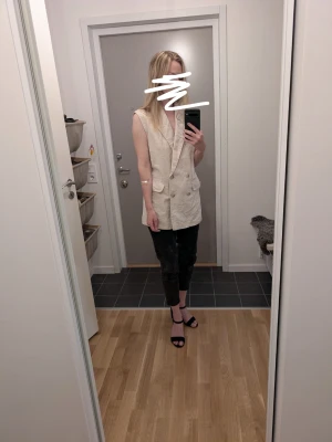 Väst i linneblandning x HM - Stilren beige väst med dubbelknäppning och djupa slag. Västen är lång, perfekt för att lyfta en outfit. Passar dig som gillar en trendig och avslappnad look.