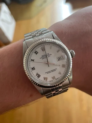 Rolex Datejust 36 mm  - Säljer nu min Rolex Datejust 36 mm i fint skick utförd i stål med vitguldsring. Klockan servades den 25 Juli 2025 och går inom 2 sekunder per dygn vilket är ett väldigt bra resultat. Orginaltillbehör och service resultat medföljer självklart vid köp.   Info:   Refnr: 16014  Årsmodell: 1985  Skick: Bra  Urtavla: Roman  Bezeln: 18 k vit guld  Boett: Stål Armband: Jubilee, stål Lås: Viklås,stål  Pris = 58 999 kr (diskuterbart)   Kom pm vid fler frågor eller bilder!   MVH Anton Fölstad