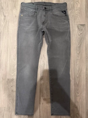 Replay Anbass Hyperflex Jeans Grå W33/L32 - Slim Fit - Replay Anbass Hyperflex grå jeans i stretchig Hyperflex denim med slim fit passform som sitter snyggt och bekvämt och funkar till allt, storlek W33/L32, midja 41,5 cm, ytterbenslängd 100 cm, benöppning 16,5 cm, modellen är 185cm & väger 65kg, i fint skick.