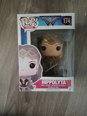 Funko Pop Hippolyta Wonder Woman - Säljer en Funko Pop vinylfigur av Hippolyta från Wonder Woman-serien, nummer 174. Figuren är detaljerad med blont hår, guldfärgad krona och rustning. Kommer i originalförpackning med fönster. Perfekt för samlare eller DC-fans. OBS!!! på höger sida är plasten lös så den går in om man trycker.