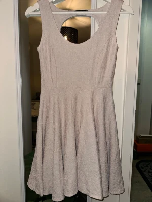 Beige/rosa ärmlös kortklänning storlek: S - Säljer en beige/rosa, ärmlös kortklänning från Made in Italy. Klänningen har en rundad urringning och lätt utställd kjol med struktur i tyget. Perfekt för dig som gillar enkel men elegant stil.