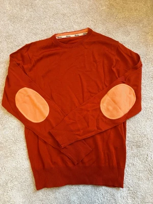 100% merino Stenströms - Snygg rostfärgad stickad tröja från Stenströms i 100% merino ull. Tröjan har ribbade muddar vid ärmslut och nederkant. Perfekt för dig som gillar klassisk men trendig stil.