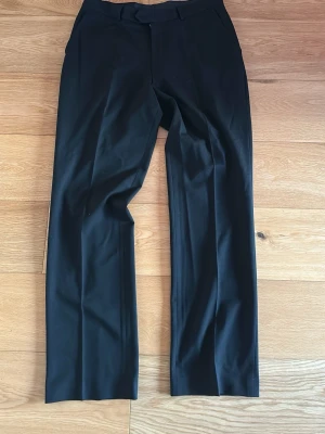Svarta bootcut kostymbyxor - Snygga svarta kostymbyxor med bootcut och pressveck från märket Steel. Det står ingen storlek men jag brukar ha 32-34 i alla mina byxor och den sitter så. Skriv om du har några mer frågor (:
