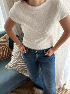 Vit fluffig topp BikBok - Vit topp från BikBok i fluffigt material.🌟  Skickas fort! 📦  Modellen har kort ärm och rund halsringning samt en lätt figurnära passform. Väldigt skön att bära och enkel att styla, går att bära den bak och fram som modellen gör på första bilden.  Storlek: L (men sitter som en m) Skick: Använd, i fint skick.