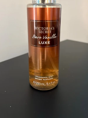 Victoria's Secret Bare Vanilla Luxe - Victoria's Secret Bare Vanilla Luxe är en body mist med doft av marshmallow och vanilj cashmere. Flaskan är i plast med en lyxig bronsfärgad ton och rymmer 250 ml. Perfekt för dig som gillar söta och varma dofter. Mer än hälften kvar. Se bild och markering.