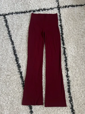 Vinröda ribbade flare leggings - Säljer ett par vinröda leggings från Alcott med ribbad linning. Modellen har utsvängda ben och är gjorda i ett mjukt, stretchigt material som sitter skönt på kroppen. Storlek S, kanske något mindre i storleken. Uppfattar dom som mid waist. Aldrig använda, endast tvättade ❤️