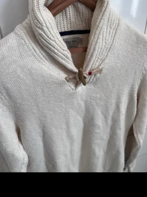 East West tröja  - Stilren vit tröja med blåa detaljer från EastWest säljes i storlek M. Något stretch men är true to size.   Tröjan är använd ett fåtal gånger. Tvättad 1 gång så skicket är som nytt. 100% bomull.  Köpt för 700kr i våras på butiken Fol