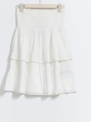 Vit kort klänning - Vit klänning med band, den har dubbel tyg. Med smock vid bröstet. Skriv privat om ni vill ha bättre bild. Pris lappen är borta men den är aldrig använd.