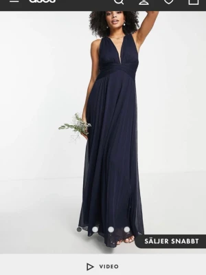 Mörkblå långklänning med v-ringning - Super fin mörkblå klänning med v-ringning som går omlott både fram och bak (se bilder). Jag är 170 och det är storlek 38 (uk 10) endast använd 1 gång så den är i mycket fint skick.