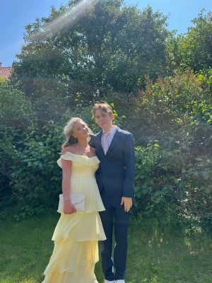 Balklänning - Säljer min ljusgula balklänning med volanger och offshoulder-modell. Klänningen är i superfint skick💛