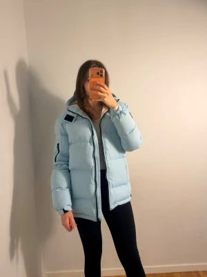 Ljusblå pufferjacka med huva - Jättefin jacka i storlek S . Inga fläckar osv , fint skick. Bra längd, jag är 170 cm 