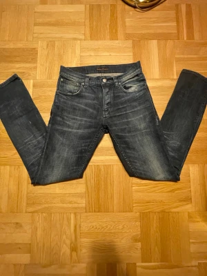 Mörkblå jeans från Nudie Jeans - Säljer ett par mörkblå jeans från Nudie Jeans med snygg tvätt och klassisk femficksmodell. 29 32