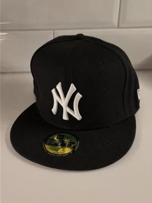 New Era New York keps - Svart New York 59Fifty keps från New Era, kepsen är i nytt skick och aldrig använd. Storlek 7 (55,8cm).