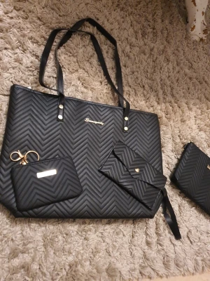 Svarta handväskor med accessoarer - Säljer en svarta handväskor. Perfekt för dig som gillar stilrena accessoarer i konstläder.