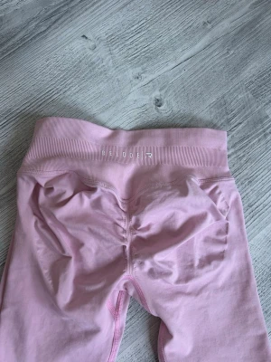 Ljusrosa leggings från Relode, aura seamless scrunch - Säljer ett par ljusrosa leggings från Relode med hög midja och ribbad linning. Materialet är stretchigt och mjukt, perfekt för träning eller chill. Snygg scrunch-detalj bak för extra form. Kommer i originalförpackning. Nypris 699kr.