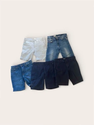 Shortspaket Märkeskläder (5 st) – Replay, Denim & Cargo (164/S) - Säljer ett komplett kit med 5 par snygga shorts inför våren och sommaren. Här finns allt en kille behöver: snygga denimshorts, praktiska cargoshorts och dressade chinos-shorts.  Totalt nypris för dessa ligger på ca 3 000 kr (bara Replay-shortsen kostar över tusenlappen nya). Skick: Mycket fint skick! Hela och rena, ser sparsamt använda ut.  Storlek: Överlag 164–166 (ca 13-14 år). (De ljusa shortsen är märkta 36/Small)  Styckpris: 99 kr/st.  PAKETPRIS (Alla 5 par): 399 kr.