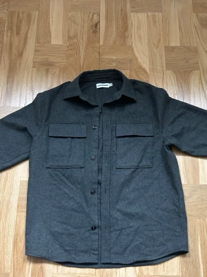 Mörkgrön - grå overshirt - J.Lindeberg  - Ganska så tunn overshirt perfekt till våren från J.Lindeberg, den är hyfsat ny, och inga defekter finns på plagget. Den är i storlek S, och är i färgen mörkgrön, vissa säger grå, men modellen ska vara mörkgrön.