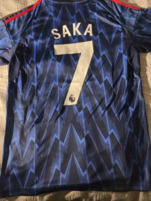 Arsenal - Saka tröja - Arsenals bortatröja för säsongen med Bukayo Saka där bak🔴🔵