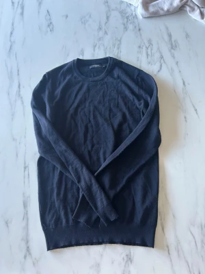 Mörkblå stickad tröja Matinique - Snygg mörkblå stickad tröja från Matinique med rund halsringning och långa ärmar. Tröjan har en klassisk, enkel design och är tillverkad i mjukt material som passar perfekt till lager på lager. Perfekt basplagg för garderoben. Nästan nytt skick. Hör av er vid fler frågor.