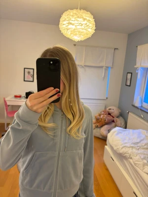 Ljusblå Gina hoodie med dragkedja🩵💗 - Mjuk ljusblå hoodie i velour från Gina Tricot. Hoodien har dragkedja framtill, två fickor och justerbar huva med snören. Perfekt för en chill och avslappnad stil. Långa ärmar och ribbade muddar för extra komfort.🌸💗🤗Saknar ena metallbiten på snöret-kolla sista bild💓✨