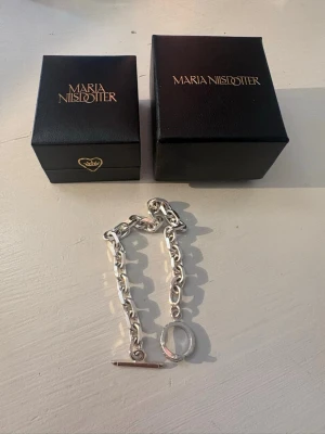 Silverarmband från Maria Nilsdotter - Säljer ett chunky silverfärgat armband från Maria Nilsdotter med grova länkar och en snygg toggle-låsning. Armbandet har en modern och stilren design som verkligen sticker ut. Kommer i original askar från märket.  Nypris 3995 kr !!!!