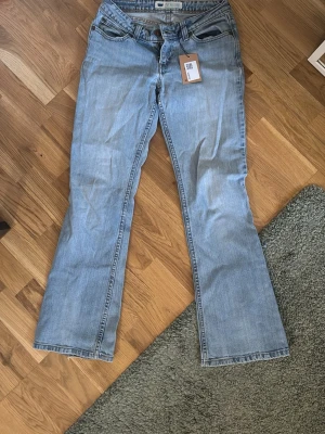 Ljusblå bootcut jeans från Levis - Snygga vintage ljusblå jeans från Levis med bootcut passform. Mindre defekt på höger ben längst ner men inget man märker (bild 4)!!
