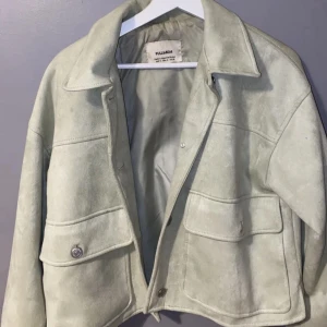 Ljusbeige mockajacka från Pull&Bear - Snygg ljusbeige mockajacka från Pull&Bear med croppad passform. Jackan har stora fickor framtill med knappar och klassisk krage. Perfekt för dig som vill ha en stilren och trendig look. ‼️‼️kan hämtas i Stockholm annars tillkommer frakt oxå‼️‼️