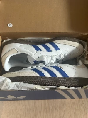 Adidas Samba  - Ett par helt nya adidas samba sneakers med blåa ränder i storlek 36 2/3. De har prislapp kvar och man får originalkartongen till vid köp. Skriv vid fundering! 🩵💙