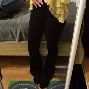 Svarta bootcut byxor Divided XXS - Svarta bootcut byxor från Divided by H&M i storlek XXS. Byxorna har hög midja och är tillverkade i en mjuk viskosmix med stretch för en bekväm passform. Snyggt utsvängda ben och enkel, stilren look som passar till allt.