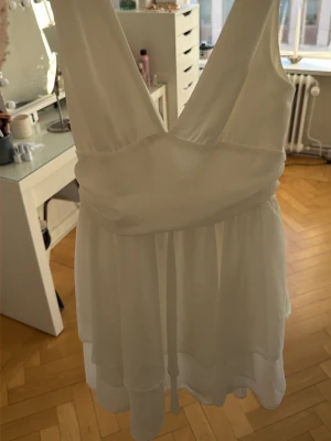 Studentklänning - Snygg vit kortklänning med omlottliv och djup v-ringning både fram och bak. Den är verkligen superfin på. Lappen finns kvar då jag tänkte ha på studenten men blev en annan💖