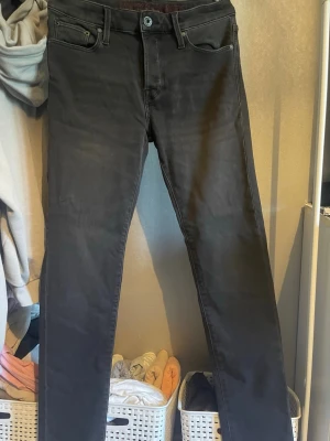 Svarta tapered jeans från Jack & Jones - Säljer ett par svarta jeans från Jack & Jones med tapered fit och klassisk femficksdesign. Jeansen har normal midja och smalnar av nedtill för en snygg siluett. Perfekta till en avslappnad streetstyle-look.