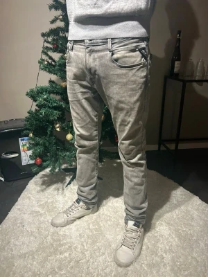 Replay Anbass Hyperflex grå jeans - Säljer ett par Replay Anbass Hyperflex jeans i grå tvättad färg. Slimmad passform med klassiska fem fickor, dragkedja och knapp framtill. Snygga detaljer på bakfickorna och stretchigt material för extra komfort. Perfekta för dig som gillar stilrena och moderna jeans. Kontakta om ni har frågor eller funderingar‼️
