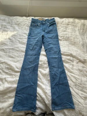 Blå bootcut jeans från Levi's - Snygga ljusblå bootcut jeans från Levi's med lite högre midja. Byxorna är aldrig använda utan endast testade, i storlek 24 i midja och 30 i längd.